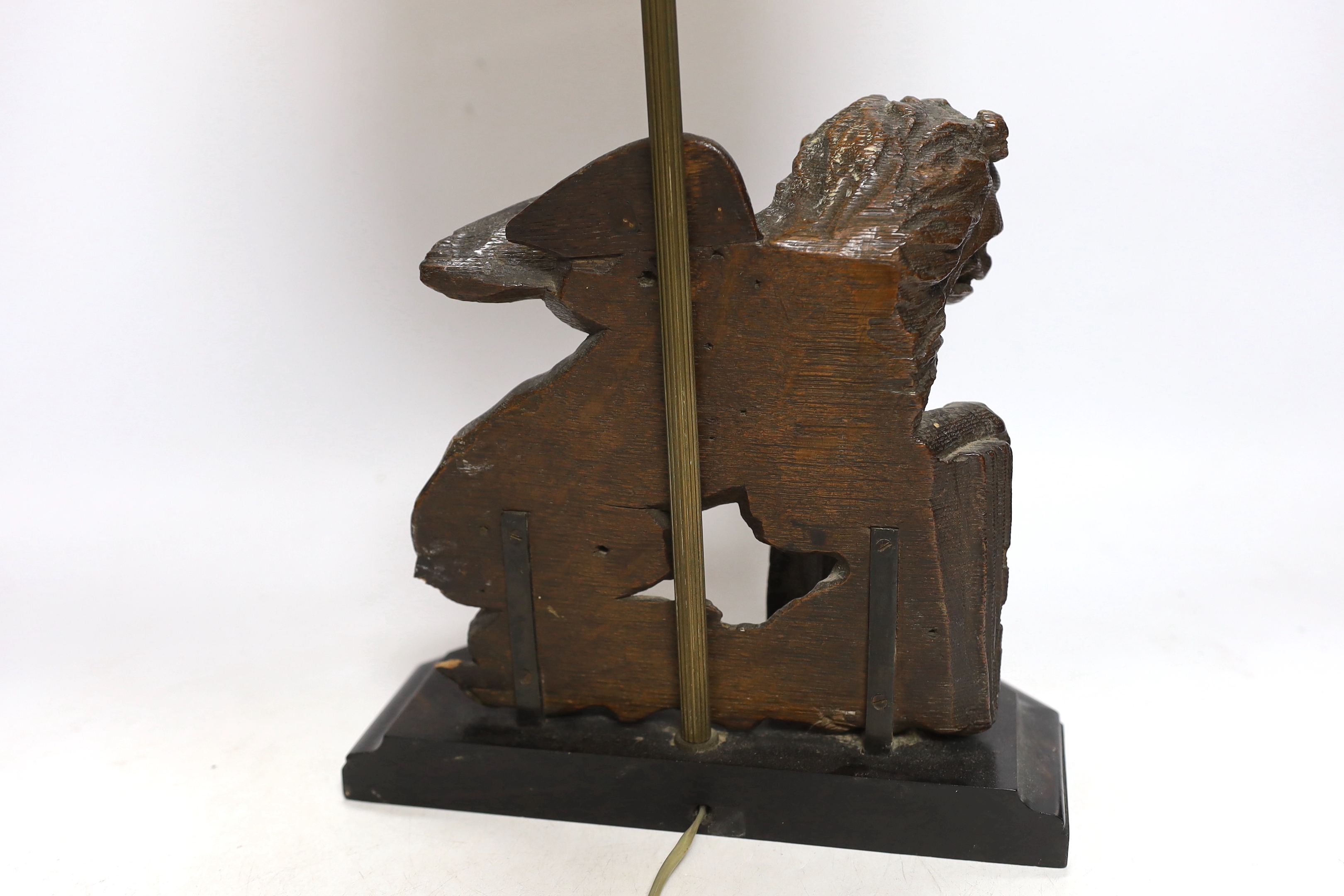 An 18th century oak carving of a Heraldic lion, now as a lamp, 55cm high including shade
